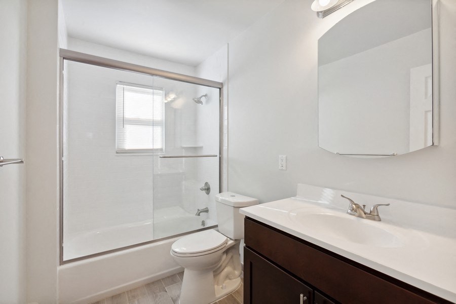 an empty bathroom with a shower toilet and sink