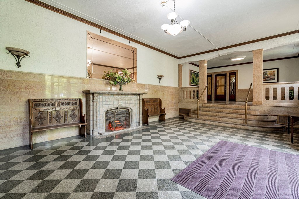 the lobby of a building with a fireplace and checkered floor