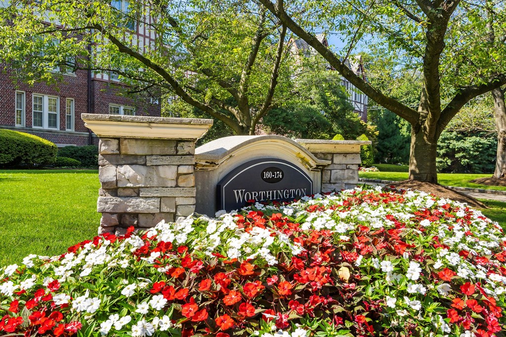 a garden of red and white flowers in front of a building