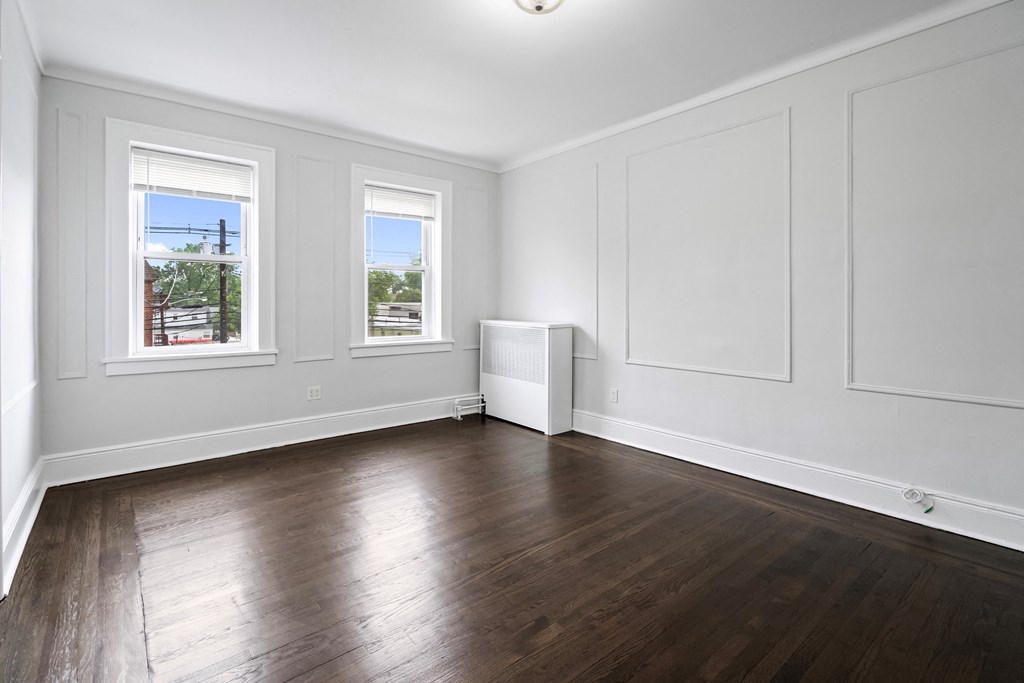 an empty living room with white walls and wood floors