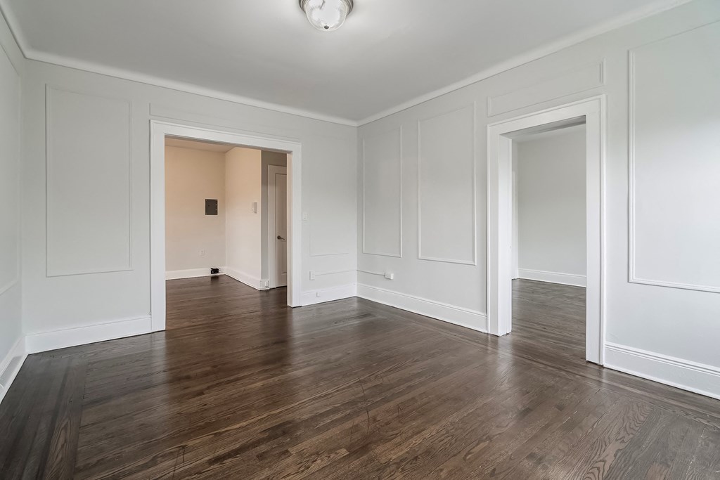 a living room with white walls and wood floors
