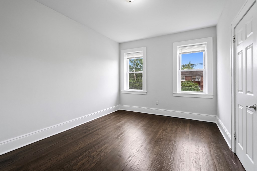 an empty living room with white walls and wood floors