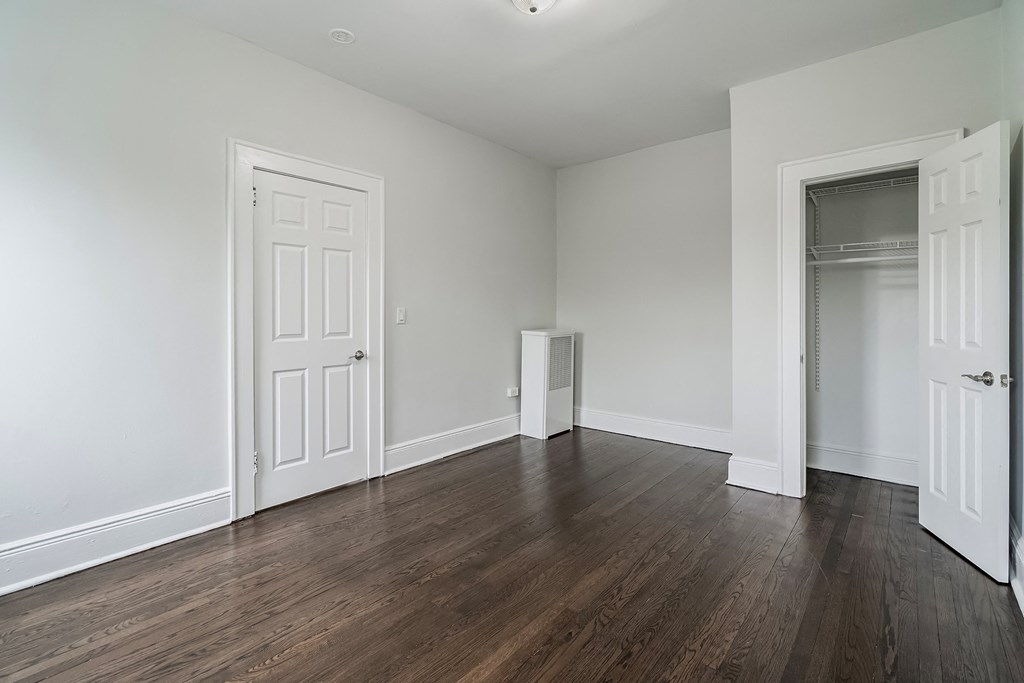 an empty living room with white walls and wood flooring