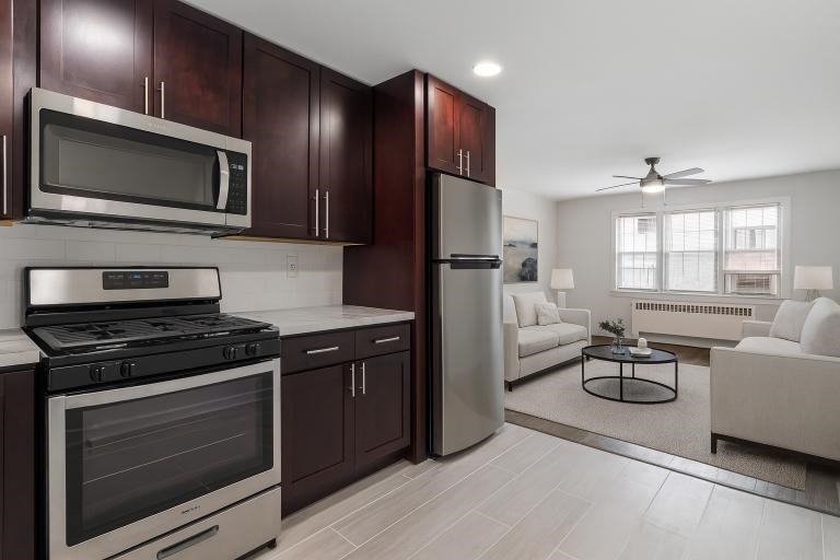 A modern kitchen with dark wood cabinets and stainless steel appliances.