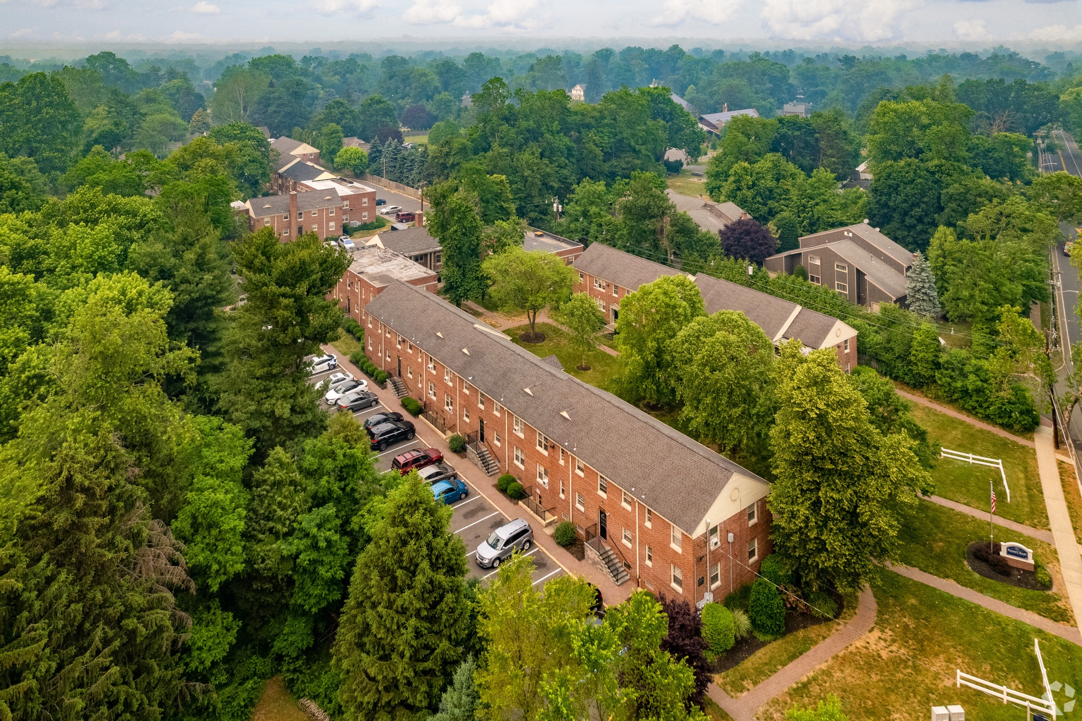 an aerial view of a brick building surrounded by trees