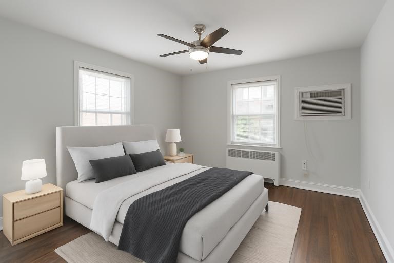 A bedroom with a bed, nightstands, and a ceiling fan.