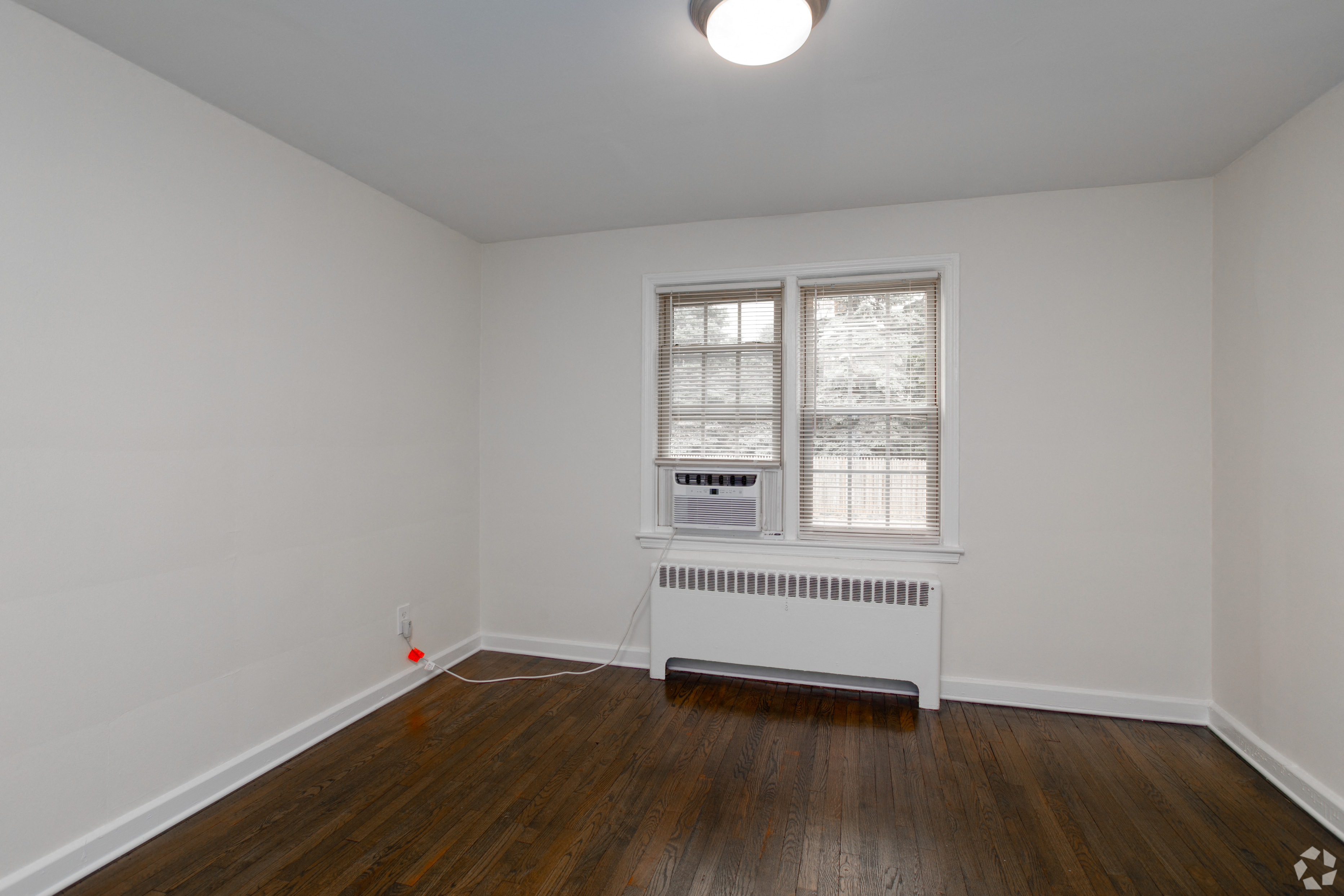 an empty room with a radiator and a window