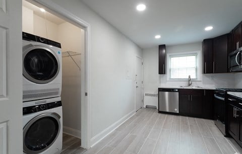 a laundry room with a washer and dryer and a kitchen with a sink
