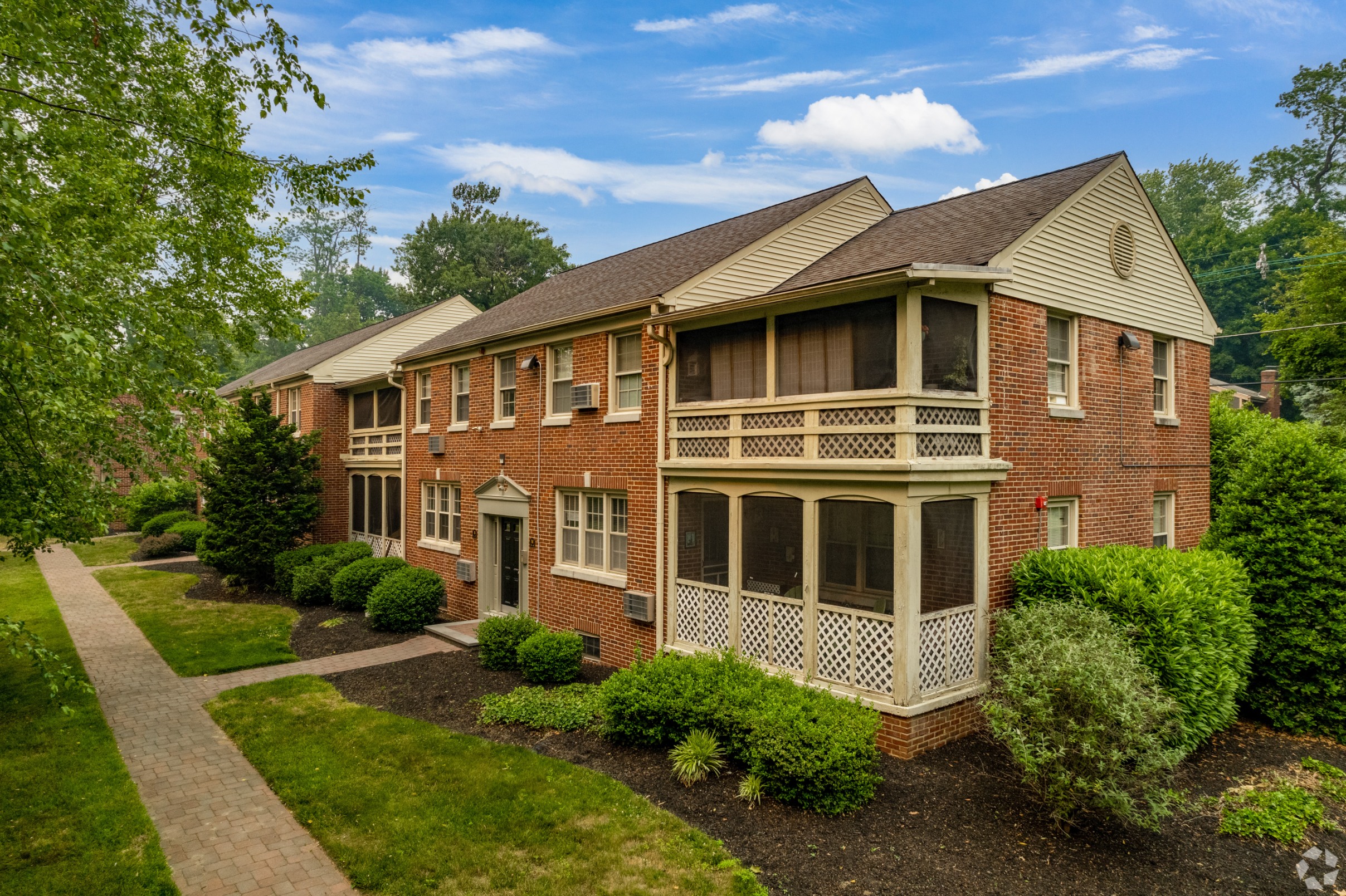 a large brick house with a porch and a pathway
