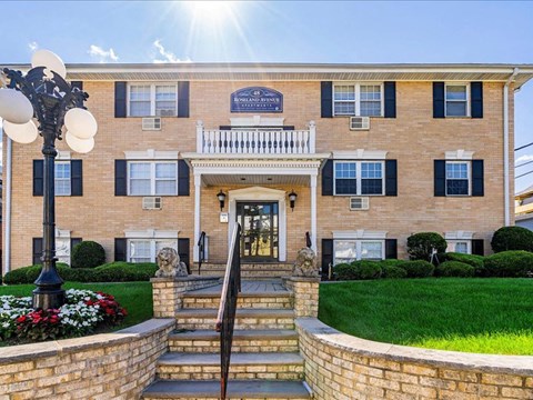 a large brick building with the sun shining in front of it