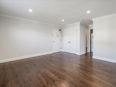 an empty living room with white walls and wood floors
