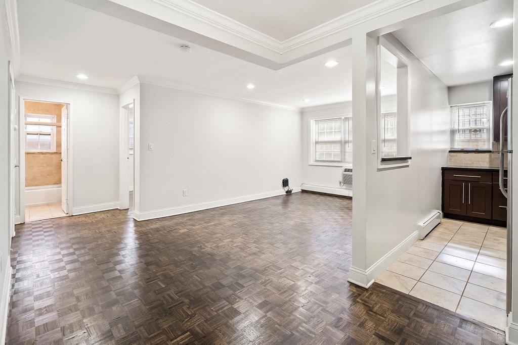 an empty living room with white walls and wood floors