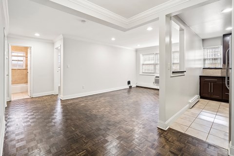 an empty living room with white walls and wood floors
