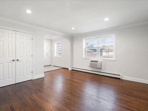 an empty living room with white walls and wood floors