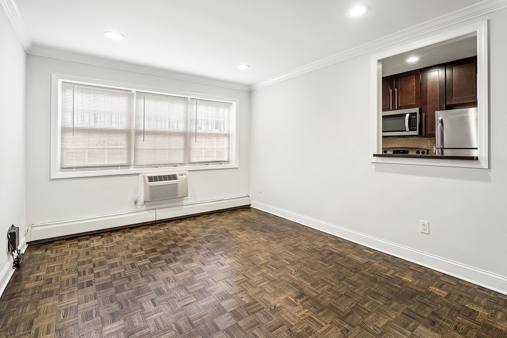 an empty living room with a window and a microwave