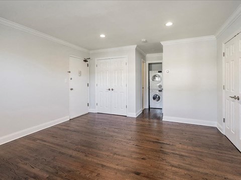 a renovated living room with white walls and wood floors