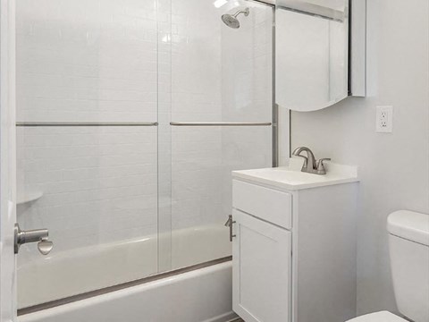 a white bathroom with a shower and a sink