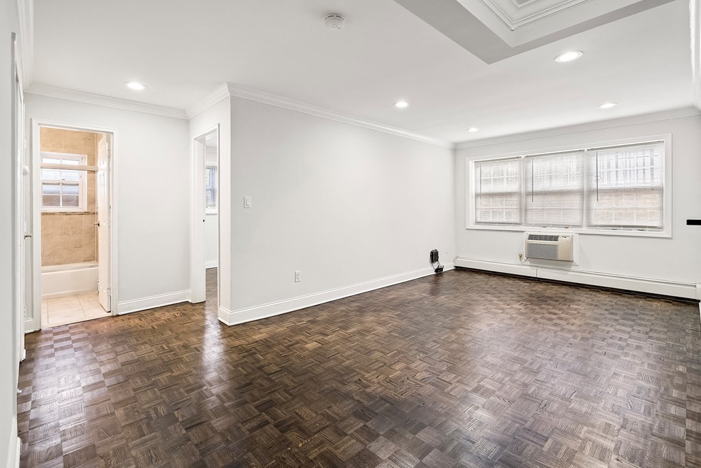 an empty living room with wood flooring and white walls