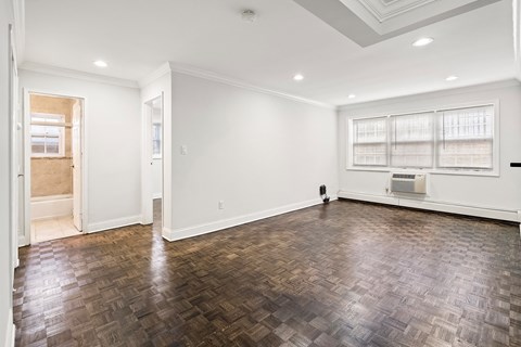 an empty living room with wood flooring and white walls