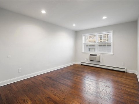 a living room with a hard wood floor and a window