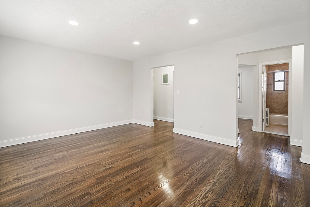 an empty living room with white walls and wood floors