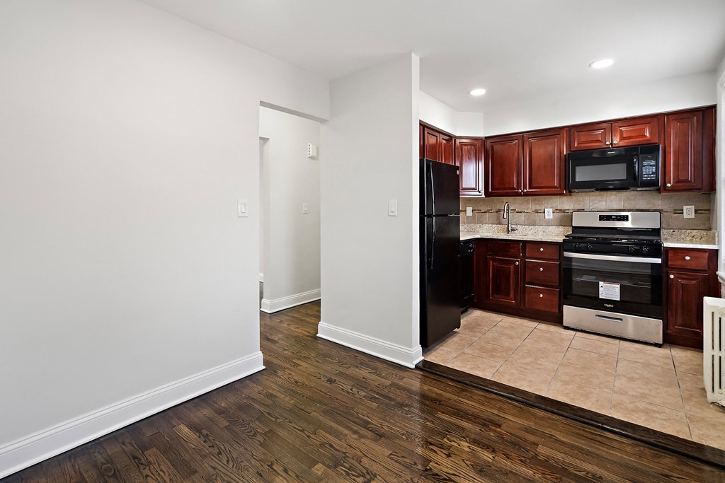 a renovated kitchen with black appliances and wooden cabinets