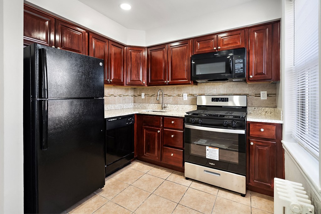 a kitchen with black appliances and dark wood cabinets