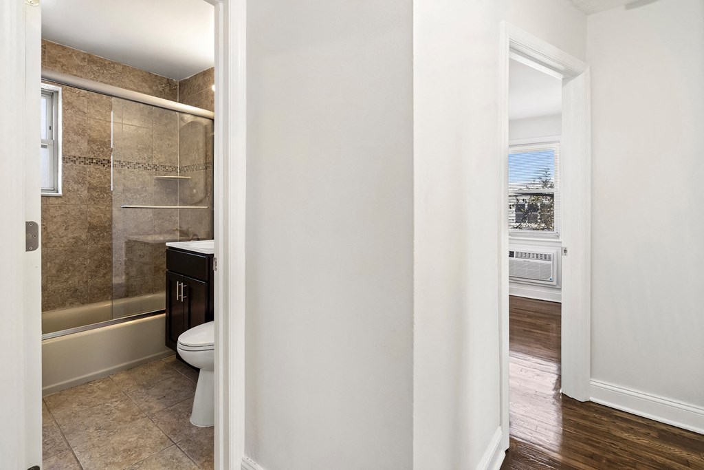 a bathroom with a toilet and a shower and a window