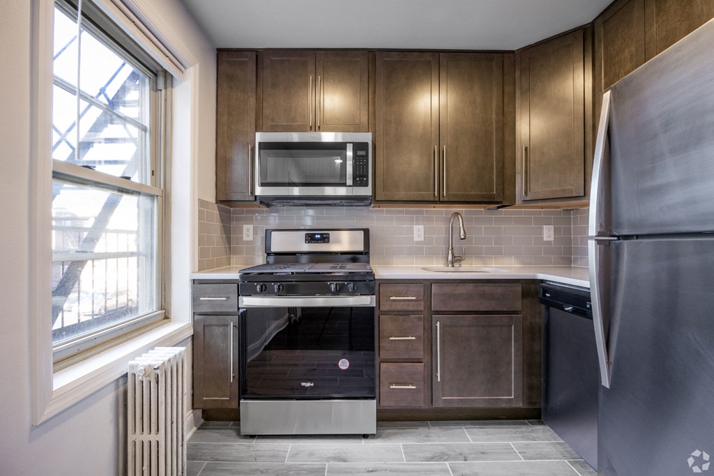 a kitchen with wooden cabinets and stainless steel appliances