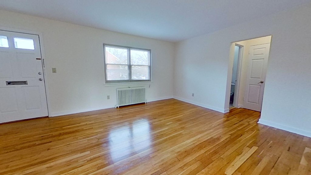 an empty living room with a hard wood floor