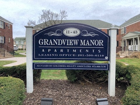 a sign apartments in front of a yard