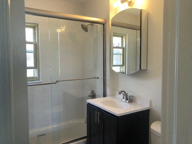 a bathroom with a shower sink and a mirror