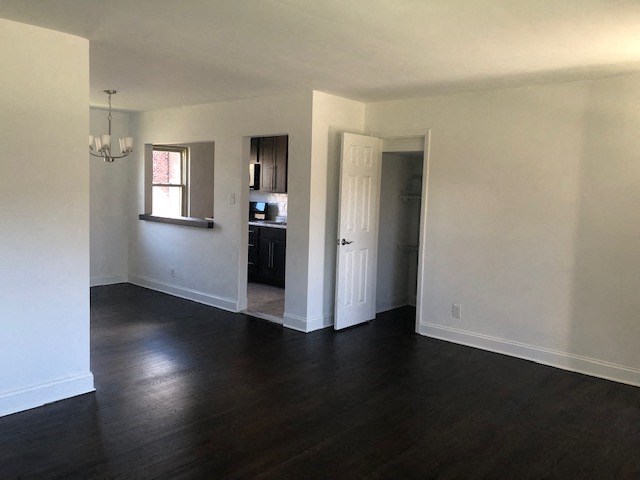 an empty living room with white walls and wood floors