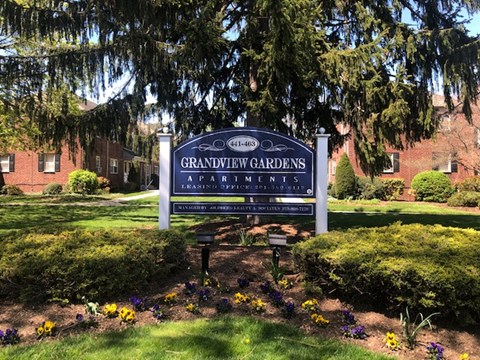 a sign in front of a yard with flowers