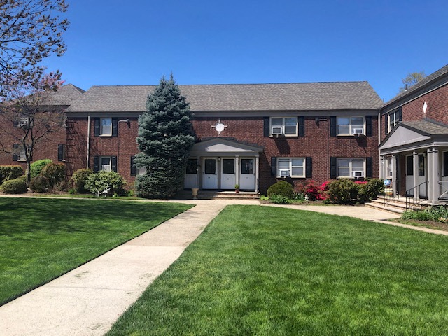 a large brick house with a lawn in front of it