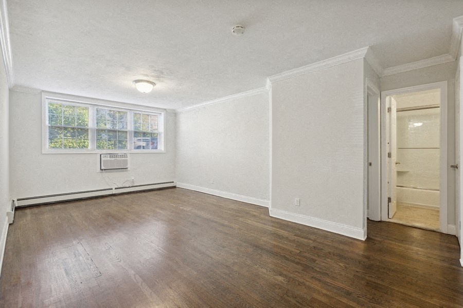 an empty living room with white walls and wood floors