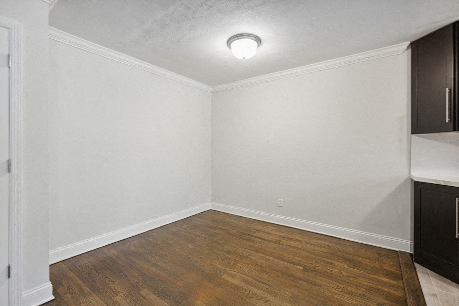 an empty living room with wood flooring and white walls