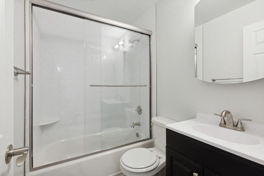 a bathroom with a shower and a sink and a toilet