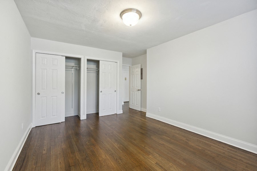 an empty living room with white walls and wood flooring
