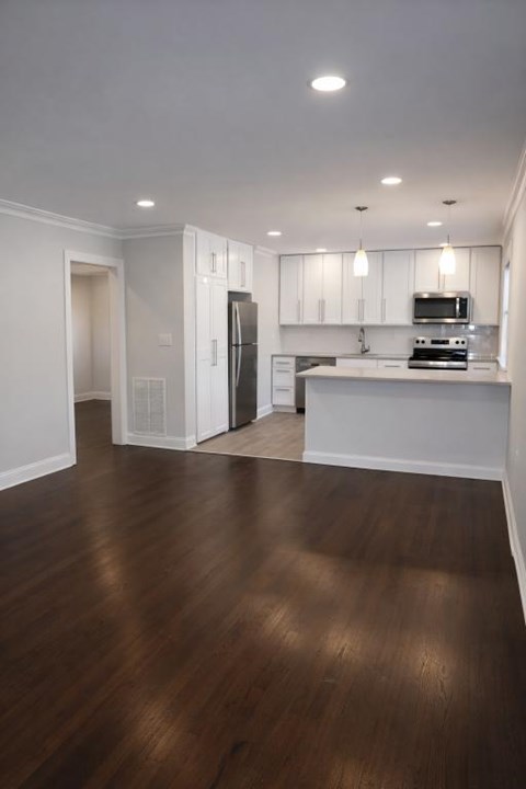 A kitchen with white cabinets and a black fridge.