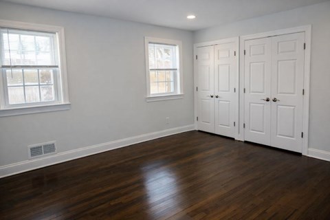 A room with white doors and a window with a white frame.
