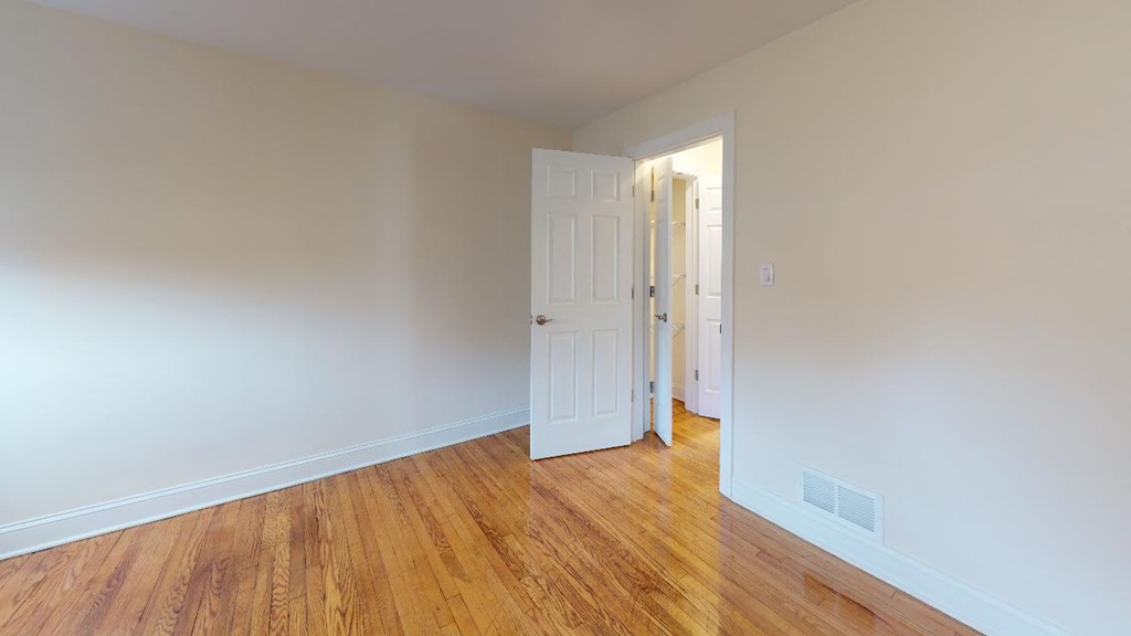 a room with wood floors and a white door