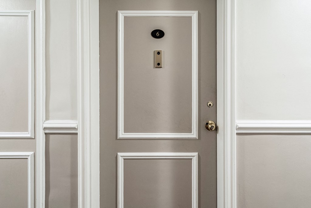 a gray door with a silver door knob and a white wall