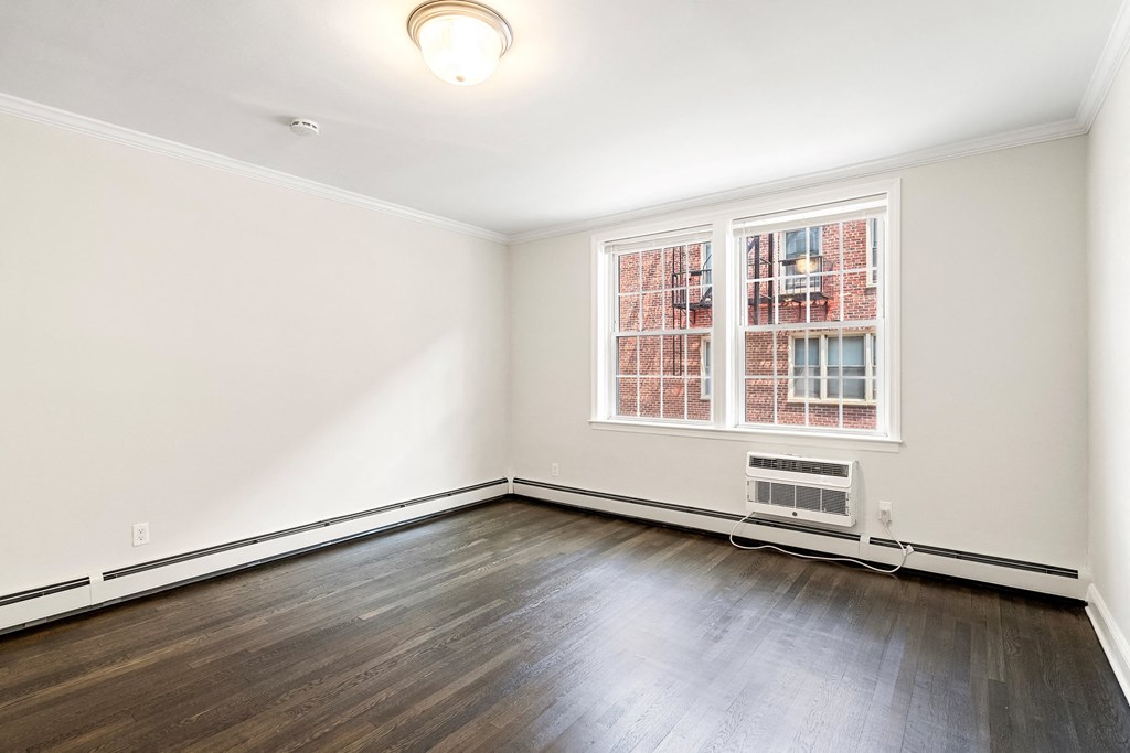 an empty living room with wood floors and a window