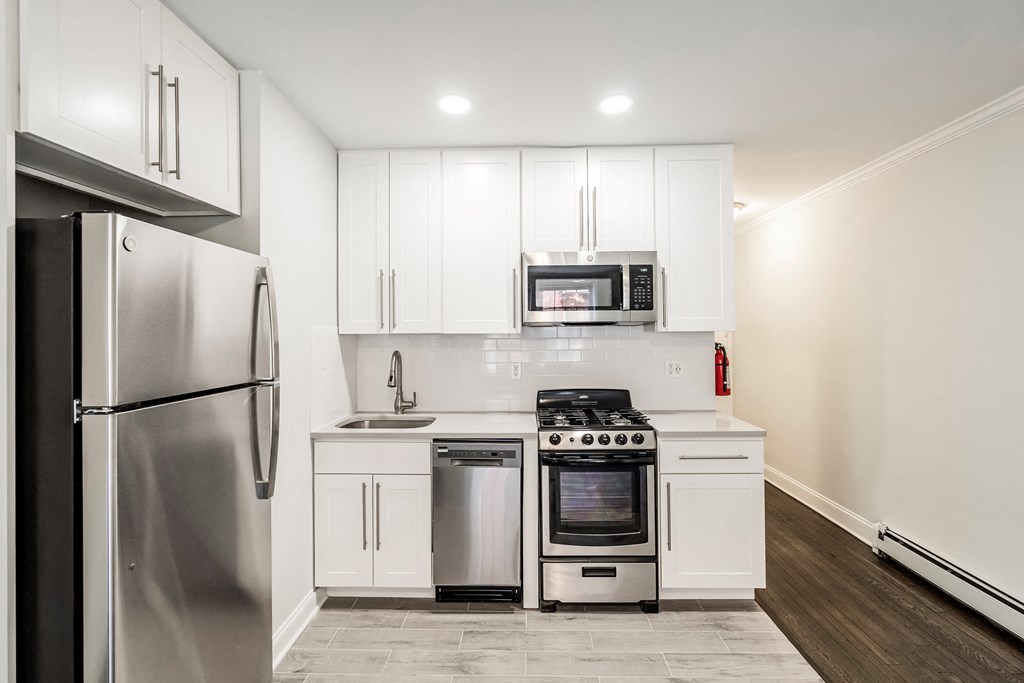 a kitchen with white cabinets and stainless steel appliances