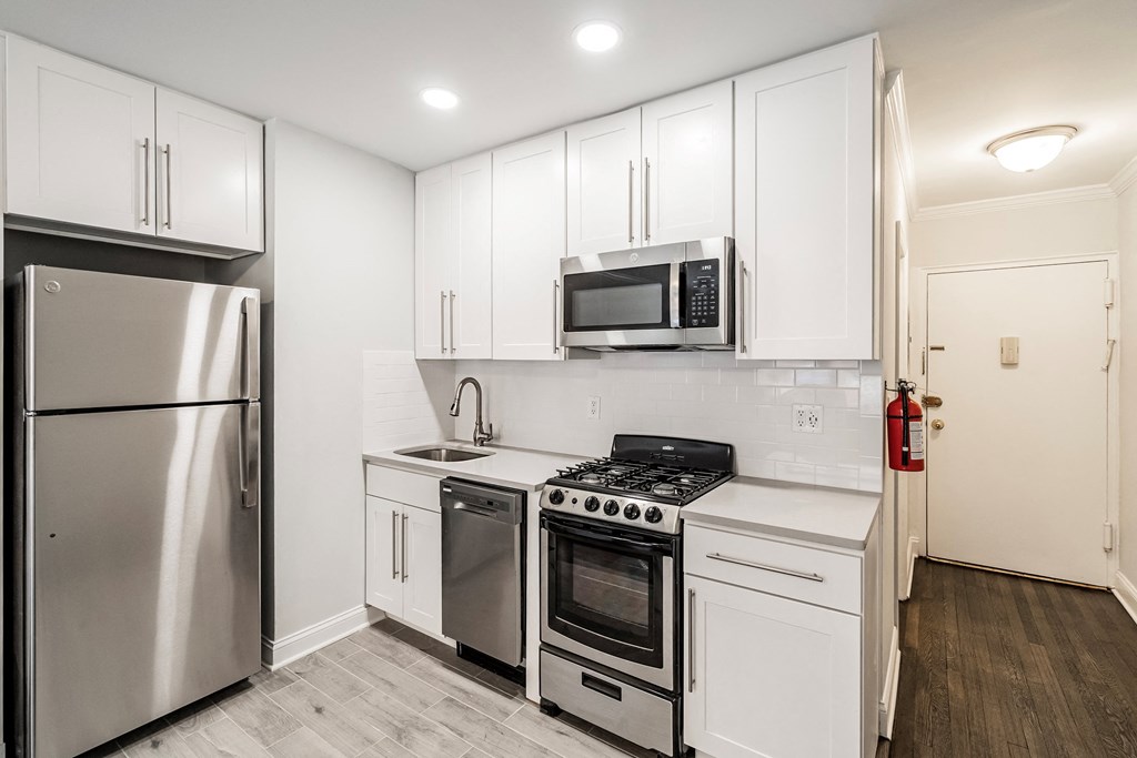 a kitchen with white cabinets and stainless steel appliances