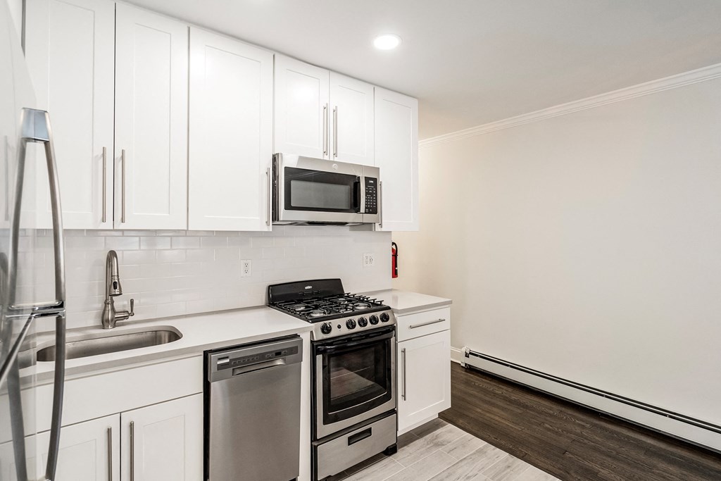a kitchen with white cabinets and stainless steel appliances