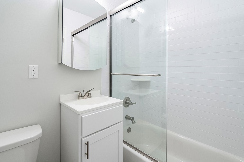 a white bathroom with a shower sink and toilet