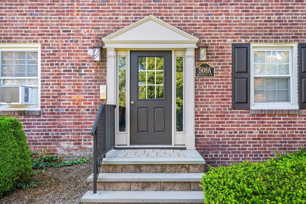 the front door of a brick house with a black door