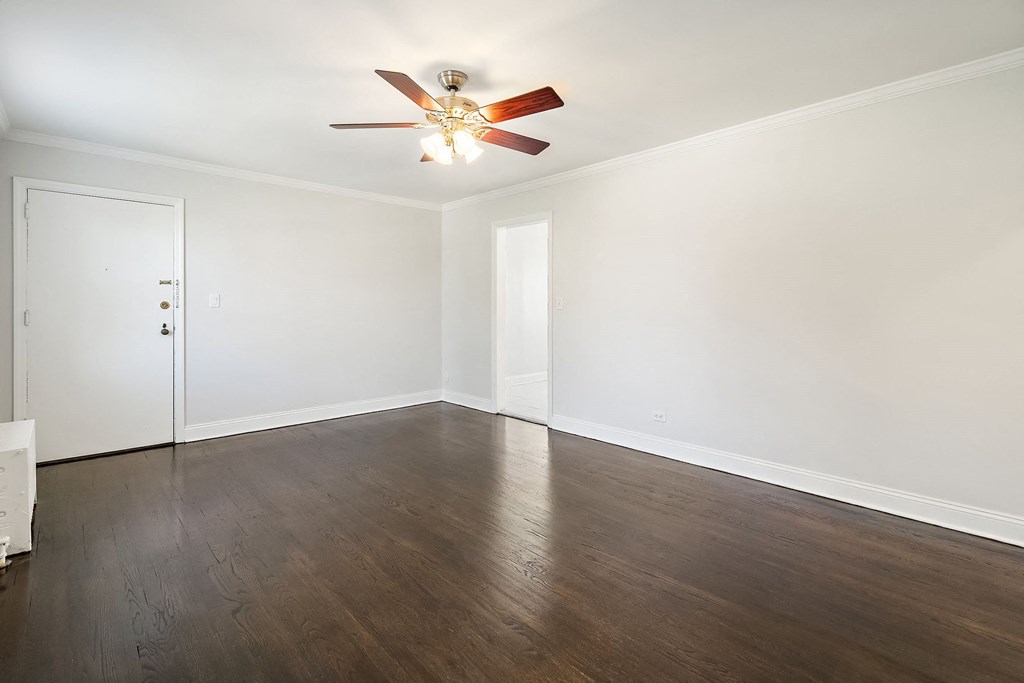 a empty room with white walls and a ceiling fan